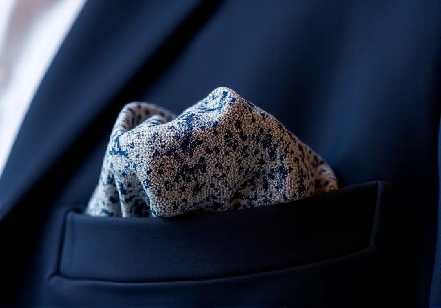 Dettaglio di una pochette di seta in un taschino di una giacca blu navy